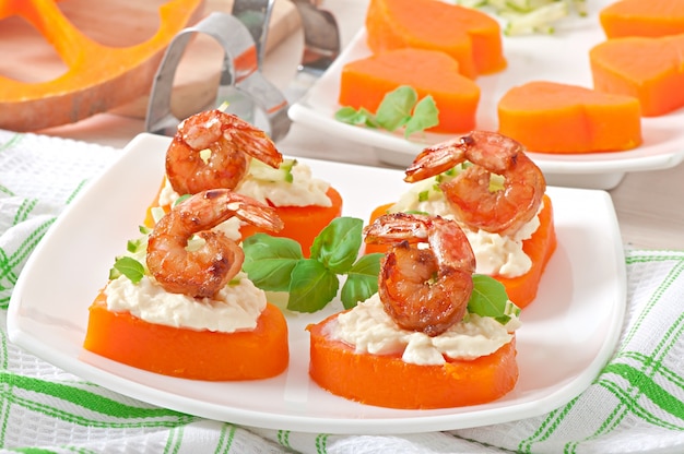 Appetizer of shrimp and cream cheese on pumpkin hearts