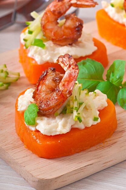 Appetizer of shrimp and cream cheese on pumpkin hearts