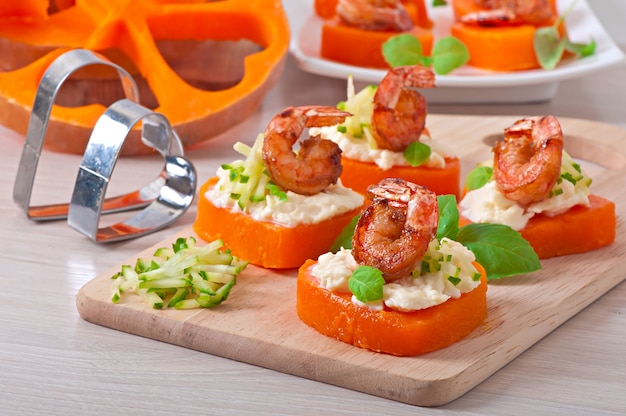 Free photo appetizer of shrimp and cream cheese on pumpkin hearts