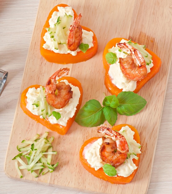 Appetizer of shrimp and cream cheese on pumpkin hearts