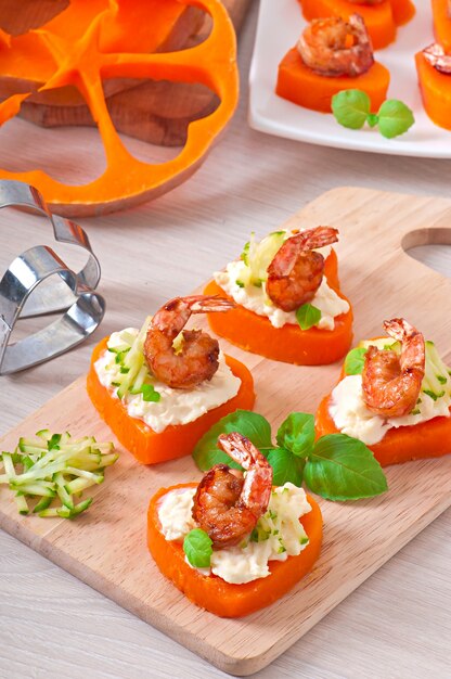 Appetizer of shrimp and cream cheese on pumpkin hearts