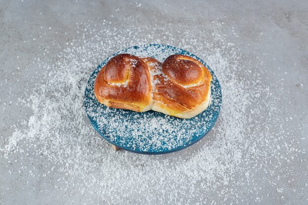 Appetizing bun on a blue stand on marble surface