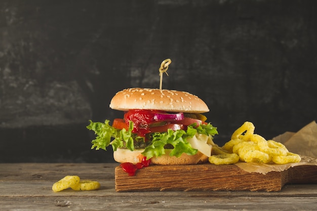 Appetizing burger with tomato sauce and onion rings