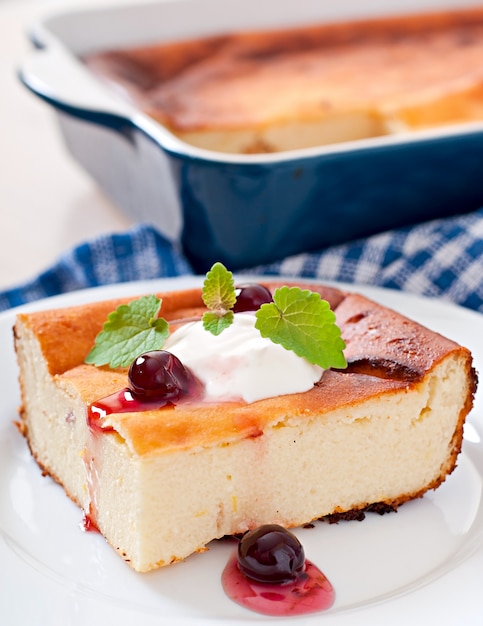 Appetizing cottage cheese casserole on white plate close up