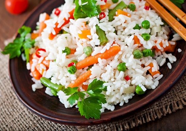 無料写真 木製のテーブルの白い皿に野菜と食欲をそそる健康的な米。