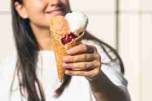 Foto gratuita un cono gelato appetitoso in mani femminili