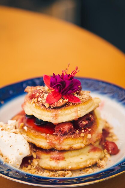 Appetizing pancakes decorated with berries and flowers