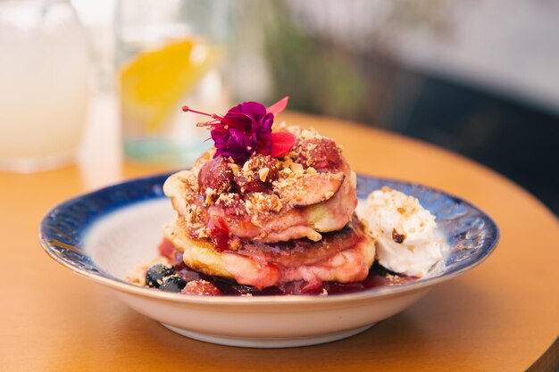 Appetizing pancakes decorated with berries and flowers