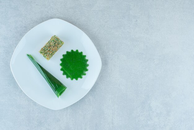 Appetizing sour cherry plum snack and lokum on the plate , on the marble background. High quality photo