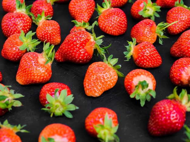Appetizing strawberries on dark table