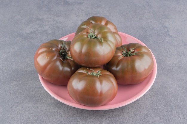 Free photo appetizing tomatoes in the plate, on the marble surface