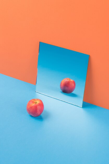 オレンジに分離された青いテーブルの上のリンゴ