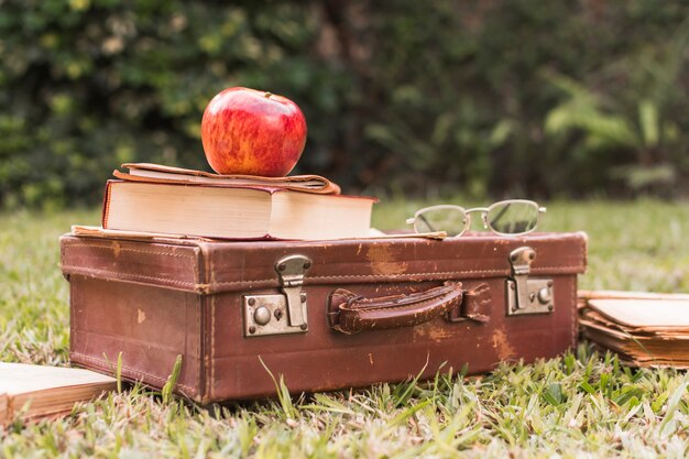アップルとスーツケースに近い眼鏡の本