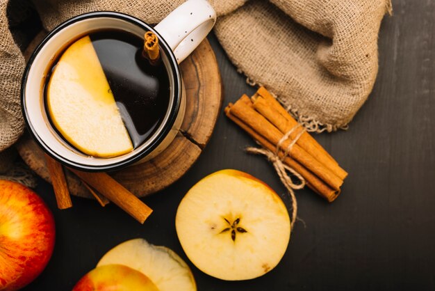 Apple and cinnamon near cloth and spiced beverage