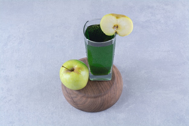 Free photo apple and juice on a inverted bowl , on the marble table.