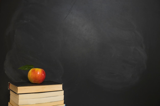 Apple laid on pile of books