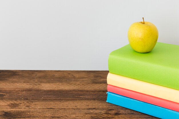 Apple lying on colorful books