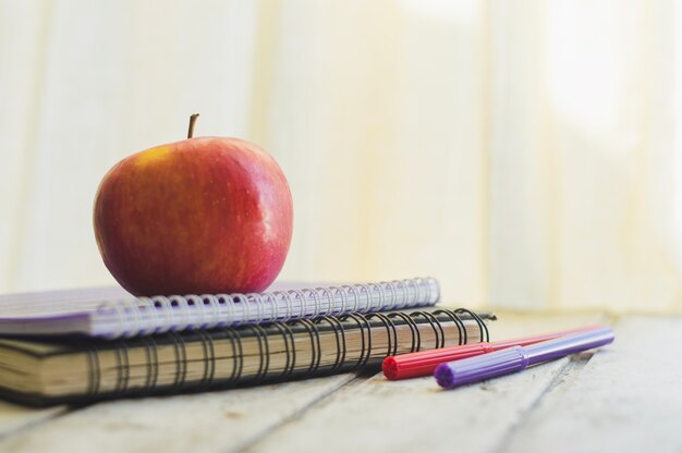 Apple on notepad with pencils