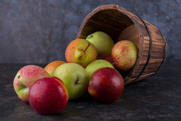 Apple, peach and pears out of a wooden bucket