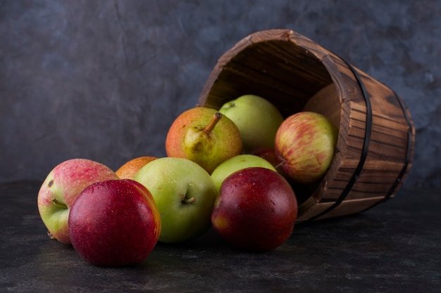 Apple, peach and pears out of a wooden bucket