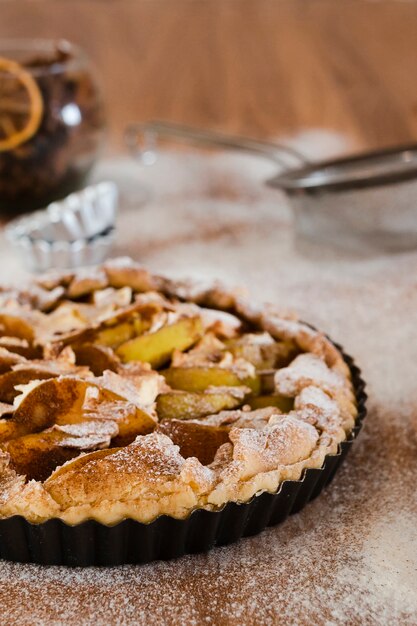 apple pie in pan with powdered sugar
