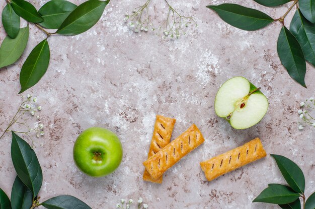Apple puff pastry cookies in apple shape plate with fresh apples, top view