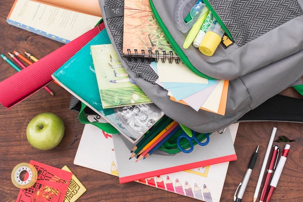 Apple and stationery near schoolbag