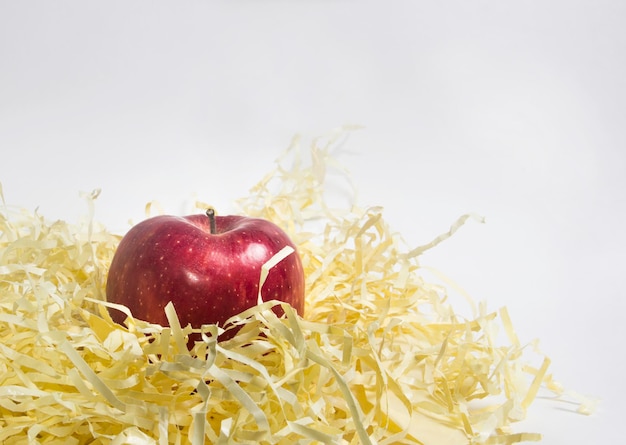 Apple in straw. wrapping paper. yellow straw Premium Photo