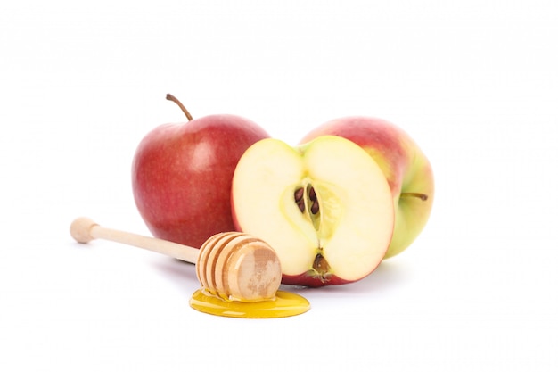 Яблоки и ковш с медом, изолированные на белом