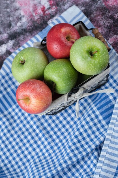 Apples in basket covered with white towel.
