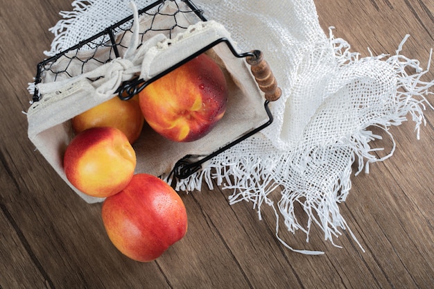 Free photo apples in a basket on a white towel on the table.