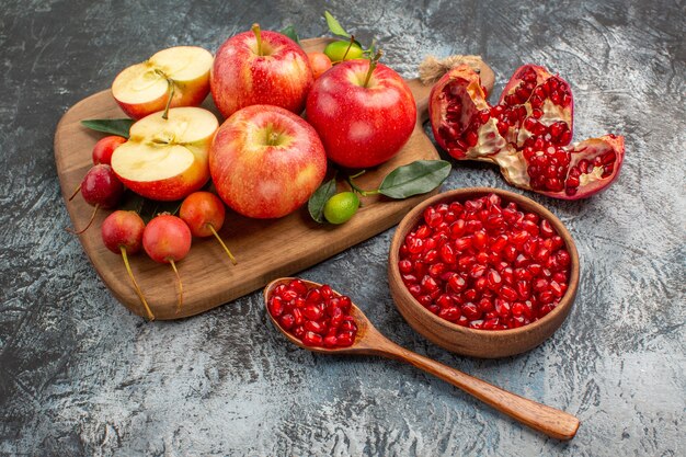 apples bowl of pomegranate cherries apples on the cutting board