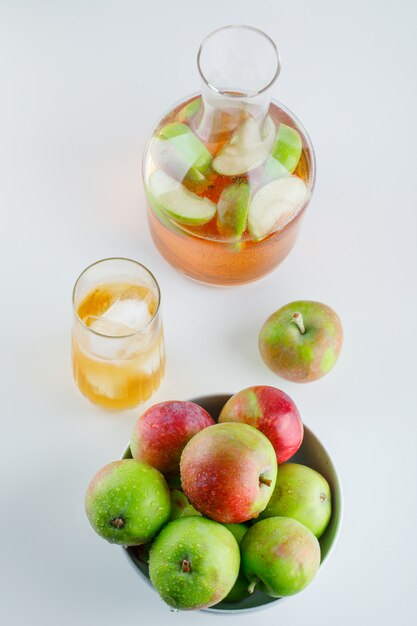 Apples in a bowl with drinks on white