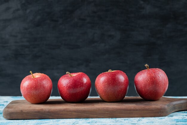 Apples isolated on a wooden cutting board