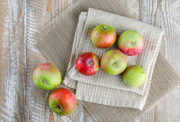 Apples on kitchen towel on wooden and placemat..