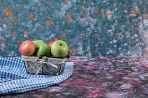 Free photo apples on metallic moni basket on blue.