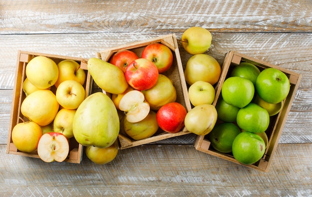 Apples variety with pears in wooden boxes on wooden