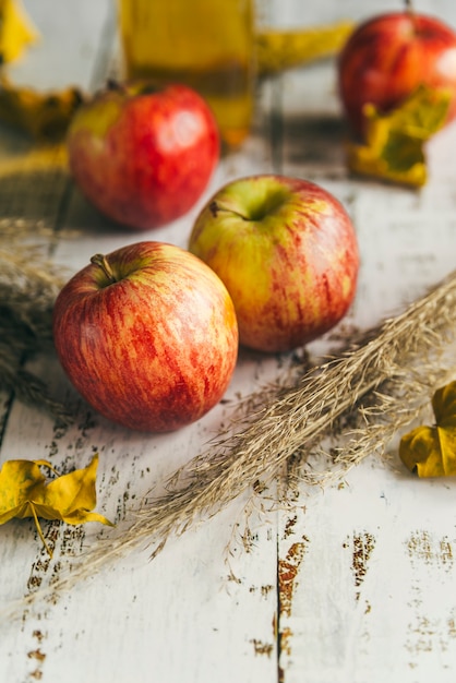Яблоки с сухими листьями на потертый стол