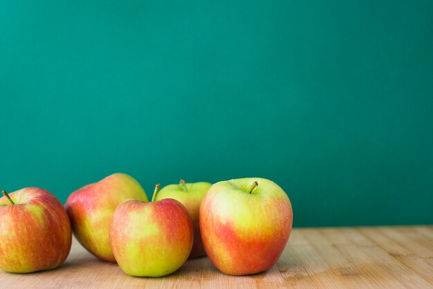 녹색 배경 나무 테이블에 사과