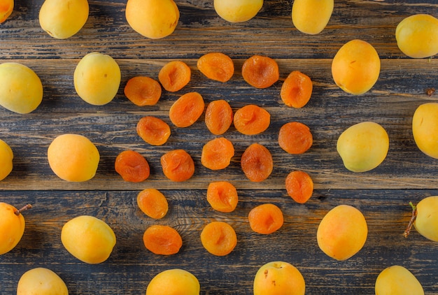 Free photo apricots with dried apricots on wooden table, flat lay.