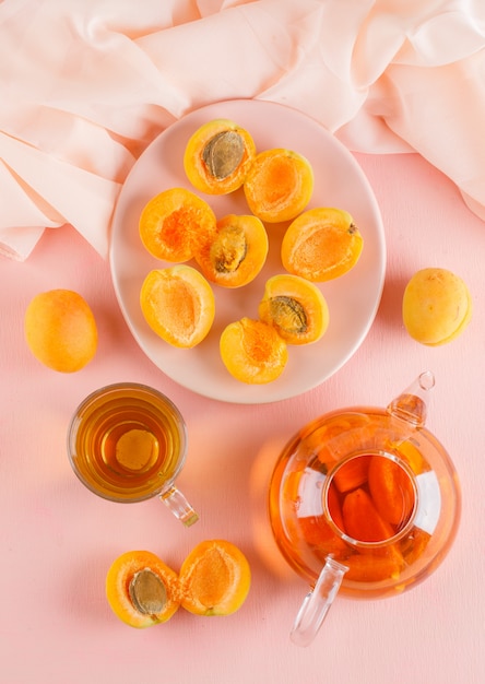 Apricots with tea in a plate, top view.
