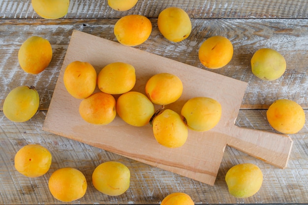 Apricots on wooden and cutting board, flat lay.