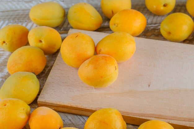 Apricots on wooden and cutting board. top view.