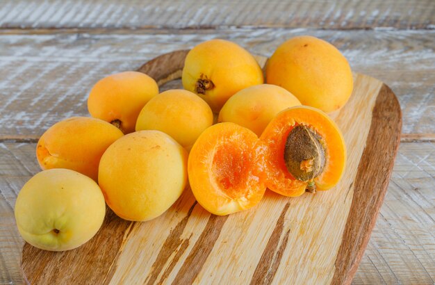 Apricots on wooden and cutting board. top view.