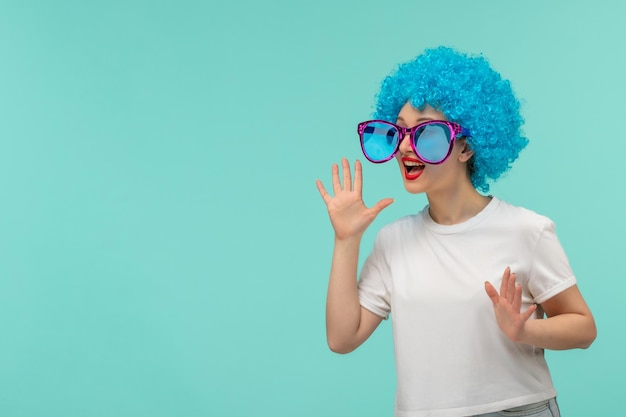 La ragazza del pagliaccio di april fools day chiama qualcuno mani per bocca grandi occhiali da sole blu costume divertente capelli blu