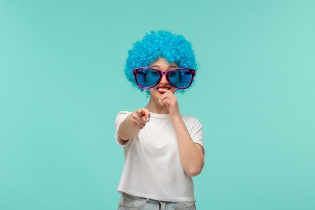 April fools day clown girl finger pointing front laughing big blue sunglas funny costume blue hair