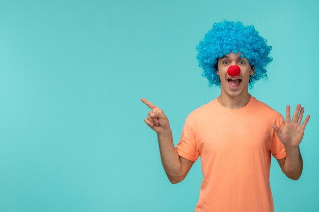 День дурака, парень, клоун, счастливый, указывая пальцем, останавливает знак, синие волосы, взволнованный, смешной, красный нос
