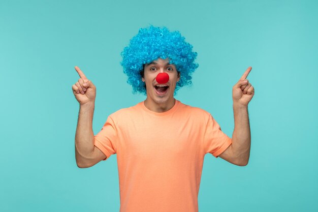 День дурака, парень, клоун, счастливый, указывая пальцами на синие волосы, возбужденный, смешной, красный нос