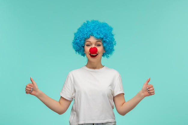 April fools day happy smiley girl very good hands geture with red nose in clown costume blue hair