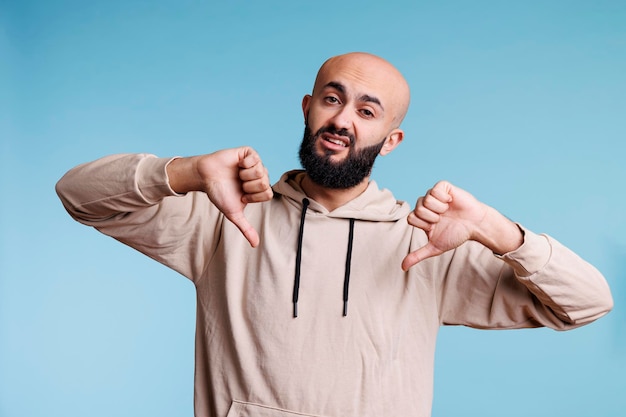 Free photo arab man showing two thumbs down